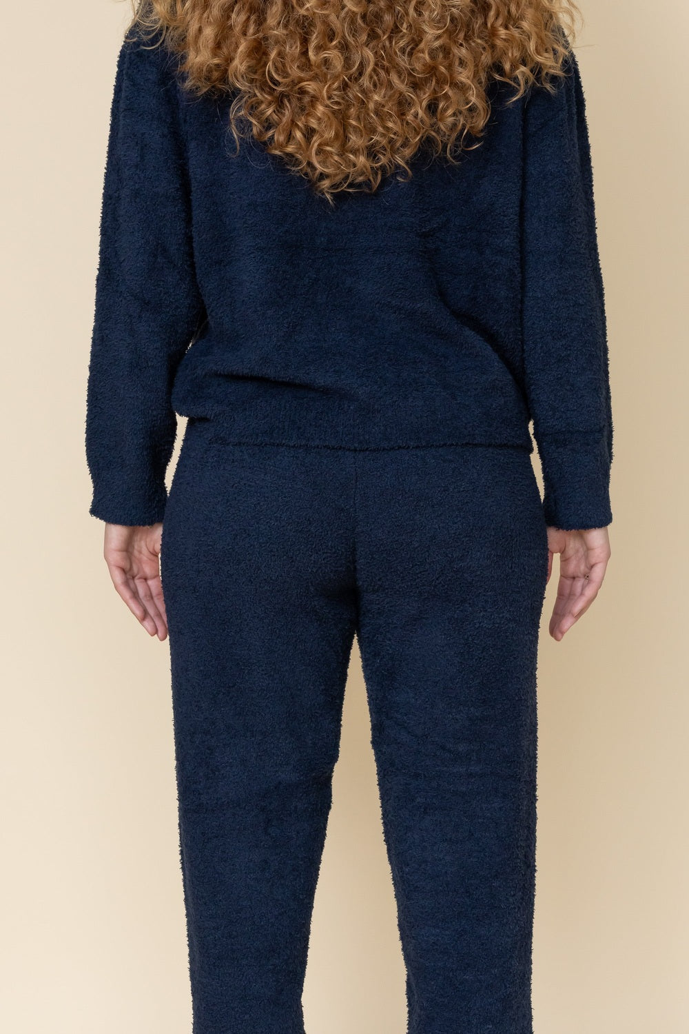 Marineblauwe fluffy trui en joggingbroek, close-up van achteren