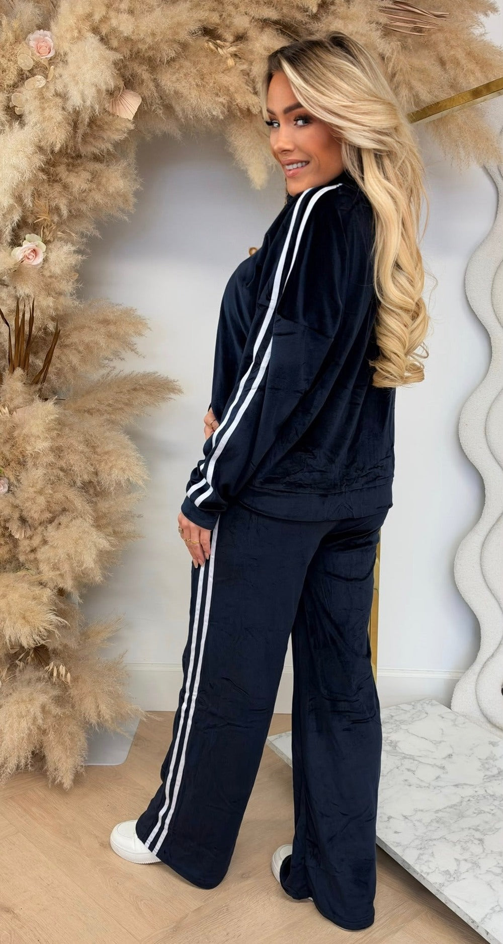 Velours joggingpak in marineblauw met witte zijstrepen, vest met rits en rechte broek, zijaanzicht