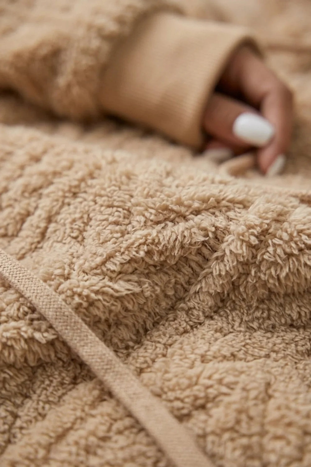 Close-up van de pluizige teddystof van de karamelkleurige trui | Boutique Moda