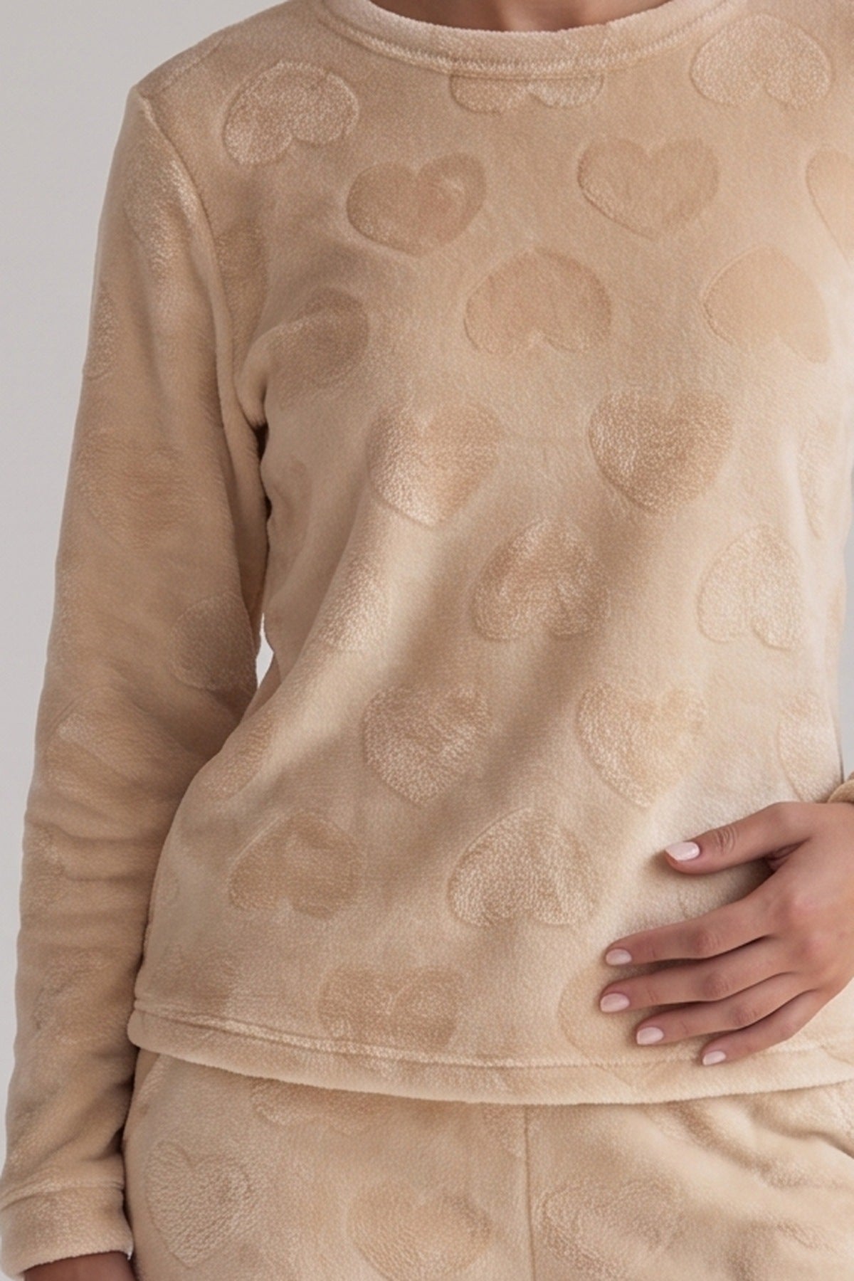 Champagnekleurige teddyfleece met ton-sur-ton hartjes, stofdetail