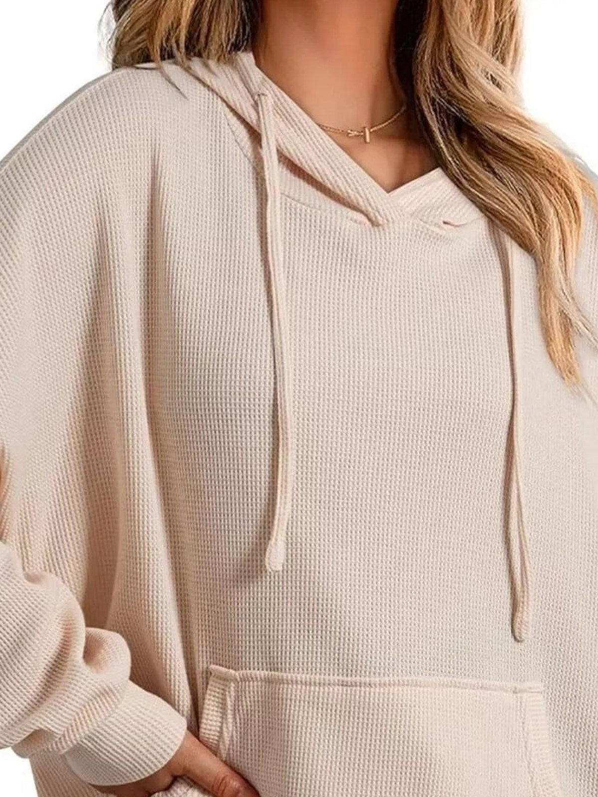 Close-up van de beige capuchontrui: V-hals, koorden, wafelstructuur en zak | Boutique Moda