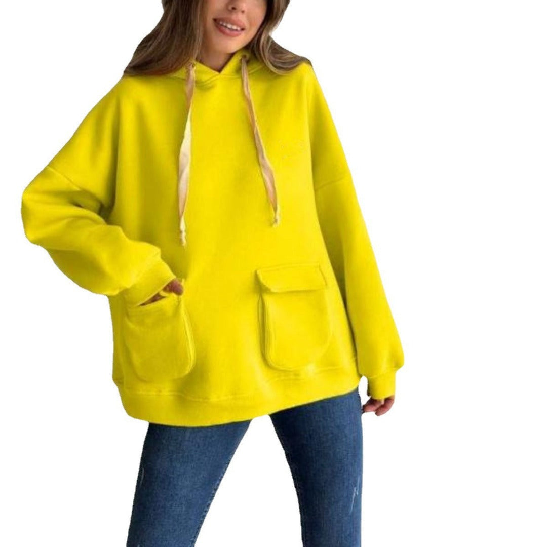 Vrouw in een neongele oversized hoodie met klepzakken en koorden, op een witte achtergrond | Boutique Moda