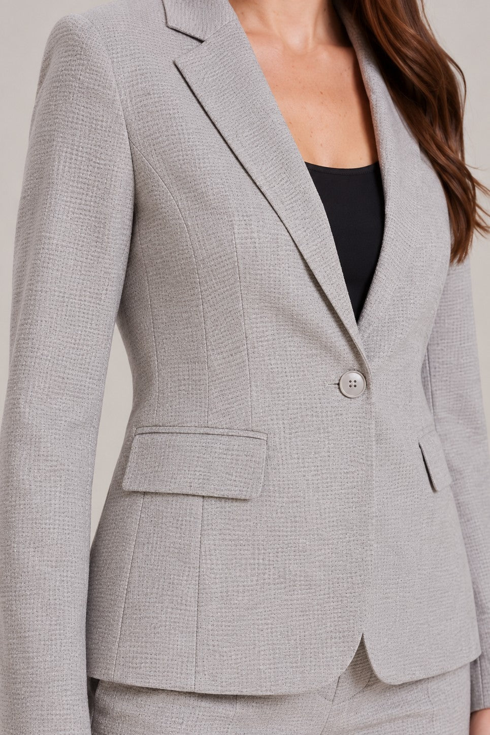 Broekpak met getailleerde blazer met één knoop en rechte broek in grijs, close-up van revers, knoop en stof