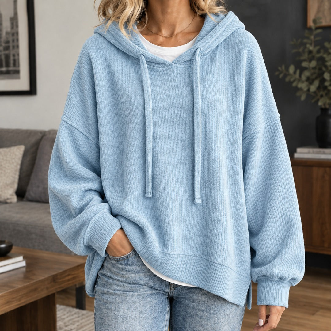 Vrouw in een lichtblauwe gebreide trui met capuchon en volumineuze mouwen | Boutique Moda