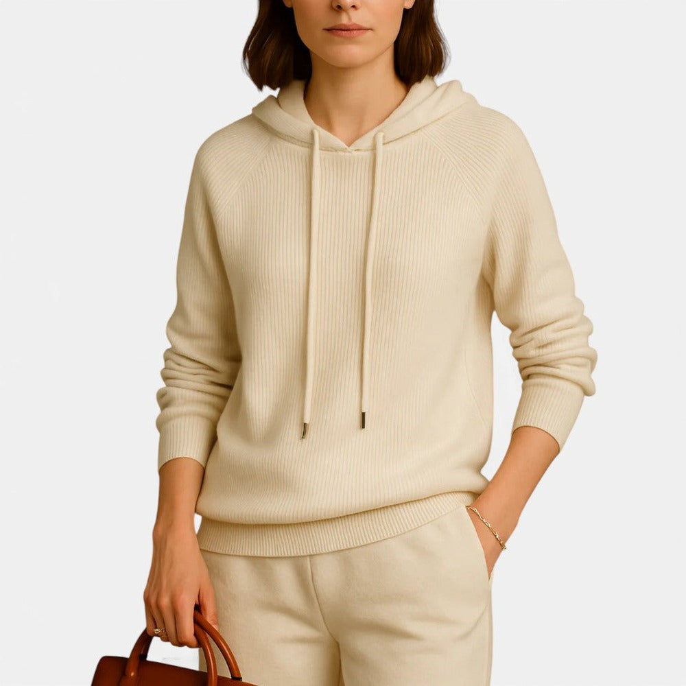 Vrouw in een champagnekleurige hoodie met koord en een bruine handtas | Boutique Moda