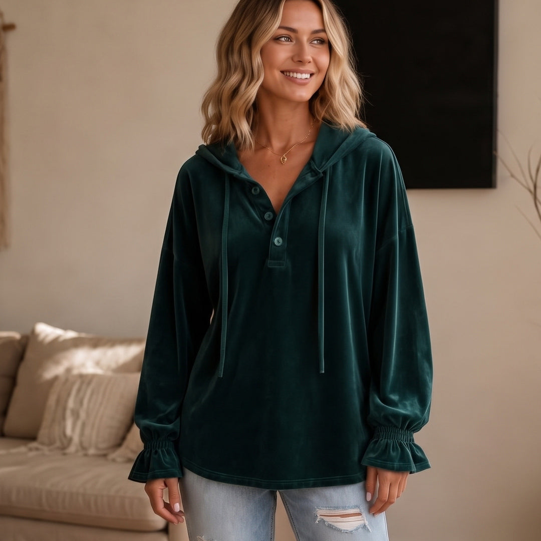 Vrouw in een donkergroene hoodie in velourslook met korte knoopsluiting, vooraanzicht | Boutique Moda