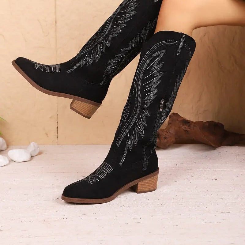 Zwarte kuithoge cowboy laarzen met geborduurd veerpatroon, gedragen door model | Boutique Moda