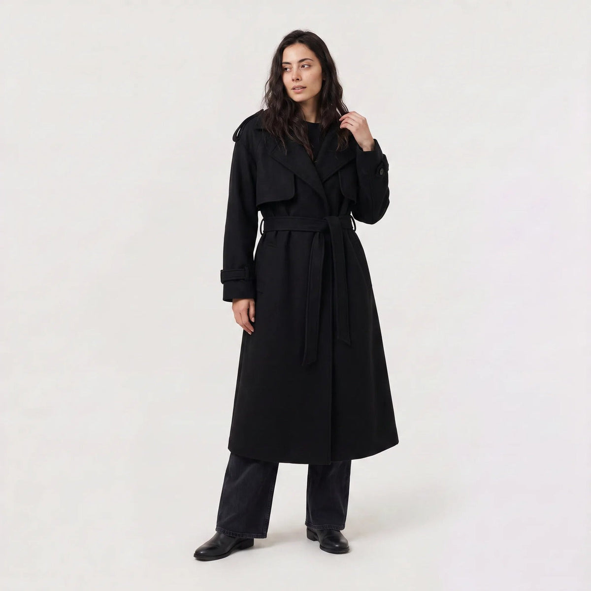 Lange trenchcoat met strikceintuur in zwart, gedragen