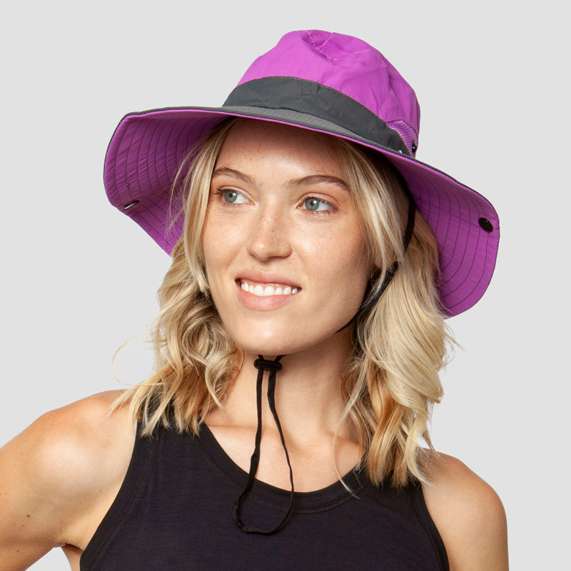 Paarse opvouwbare zonnehoed met kinband, gedragen door glimlachende vrouw met blond haar | Boutique Moda