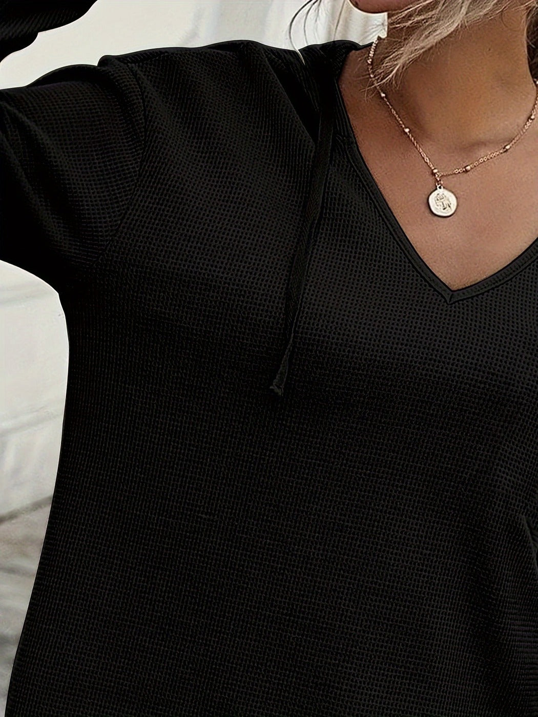 Close-up van de zwarte hoodie met V-hals en wafelstructuur | Boutique Moda