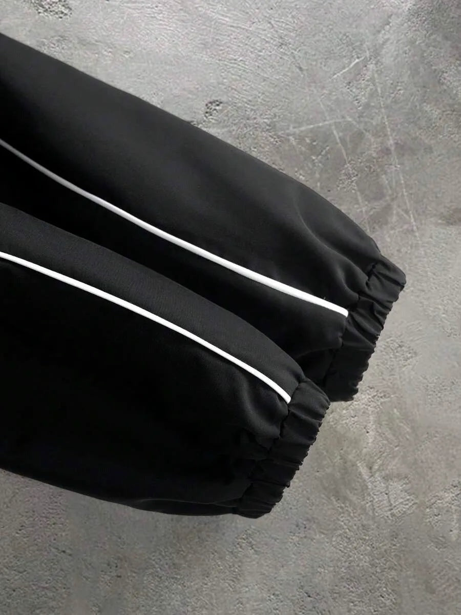 Korte herenjas met capuchon in zwart, close-up van de bies op de mouw