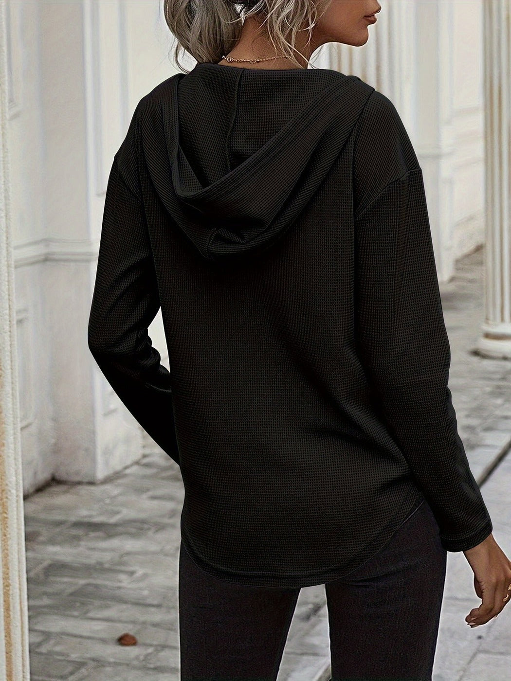 Achteraanzicht van de zwarte hoodie met capuchon en ronde zoom | Boutique Moda