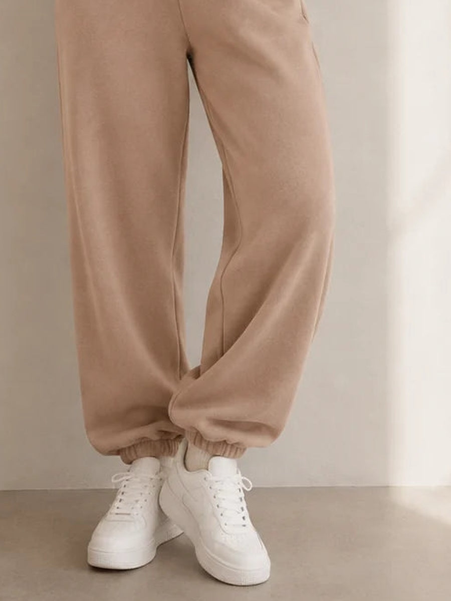 Close-up van de elastische enkelboorden van de taupe joggingbroek