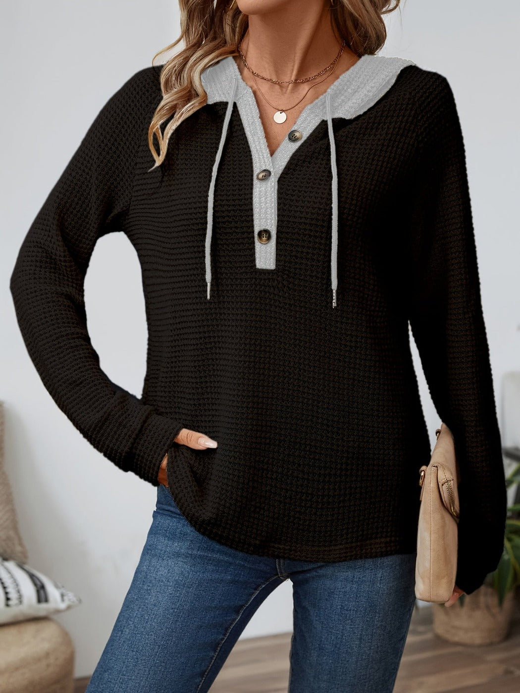 Vrouw in een wafelhoodie in Zwart/Grijs met koorden, met een tas onder de arm | Boutique Moda