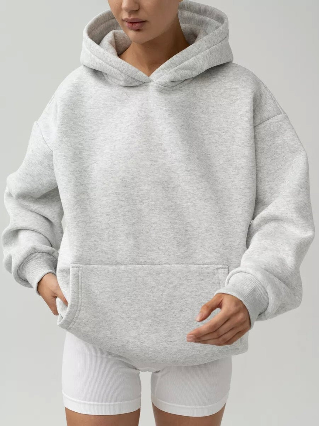 Vrouw in een hoodie in zilvergrijs met geribde boorden en witte shorts | Boutique Moda