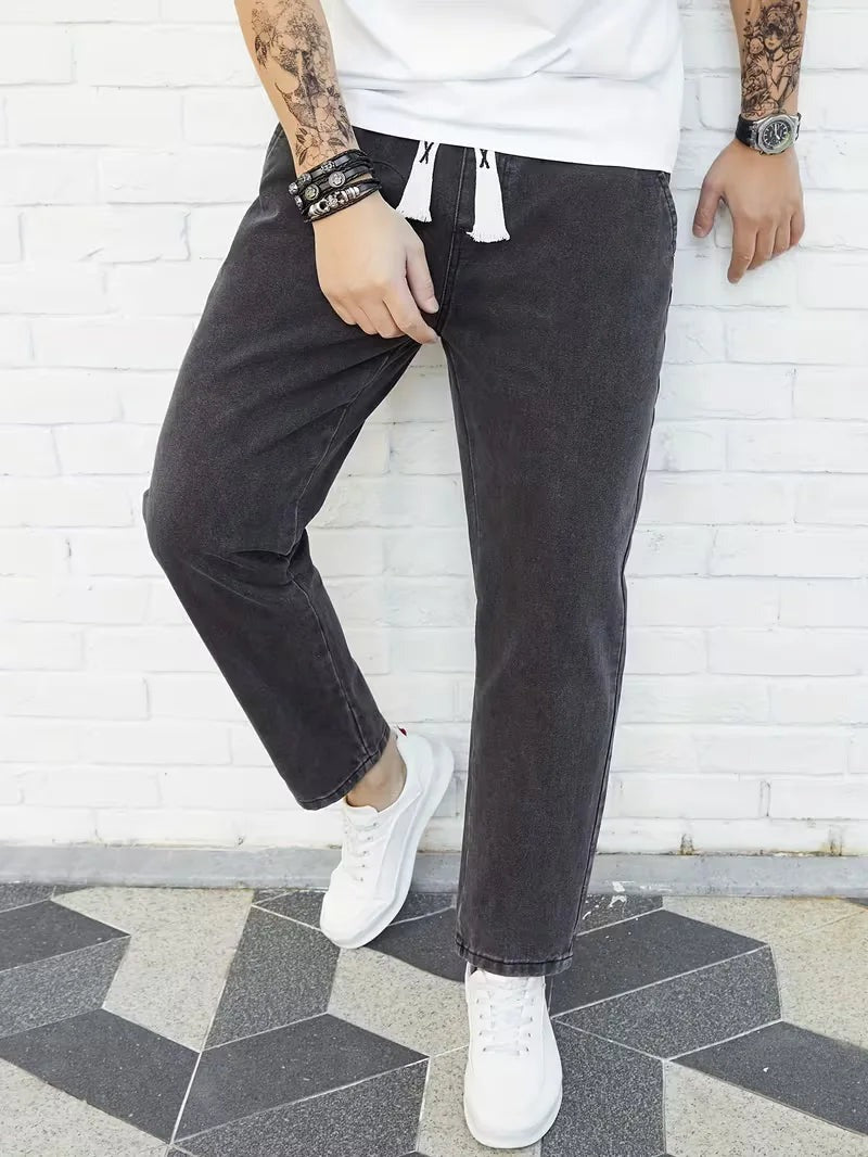 Joggerjeans voor heren in donkergrijs met trekkoord, gedragen, voorkant