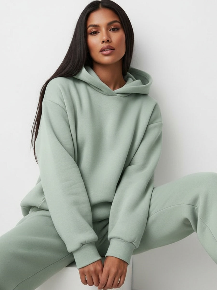 Oversized hoodie en joggingbroek in saliegroen, zittend