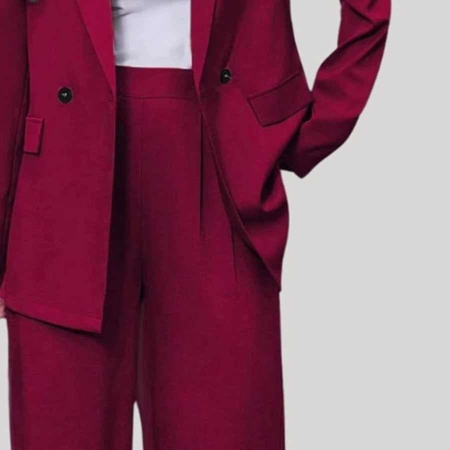 Broekpak met double-breasted blazer en wijde broek in bordeaux, close-up van de double-breasted sluiting en de bandplooien
