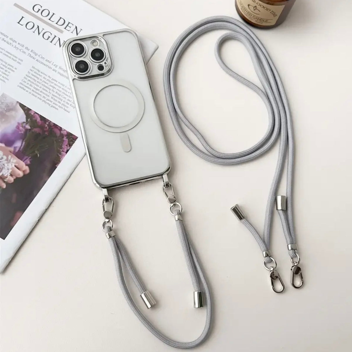 Transparant iPhone-hoesje met grijs koord en losse polsbandjes, plat neergelegd | Boutique Moda