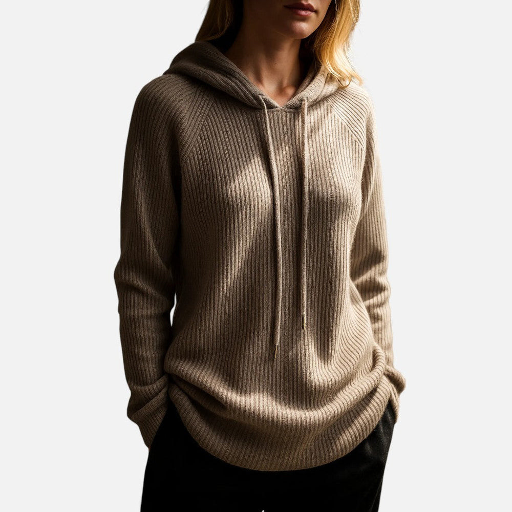 Vrouw in een bruine ribgebreide hoodie en een zwarte broek, in zijlicht | Boutique Moda