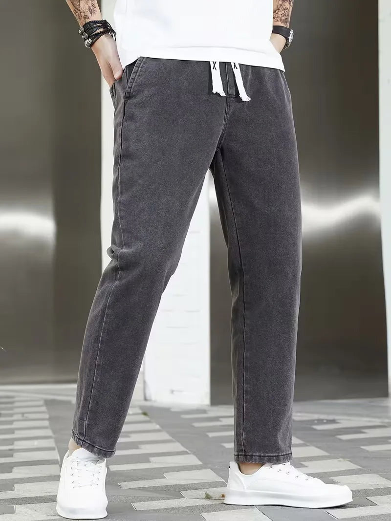 Joggerjeans voor heren in donkergrijs met trekkoord, gedragen, voorkant