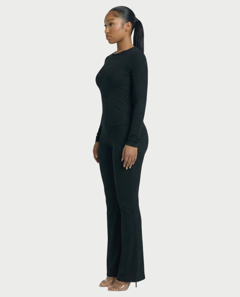 Co-ord set in zwart, strakke longsleeve en flared broek met hoge taille, zijaanzicht