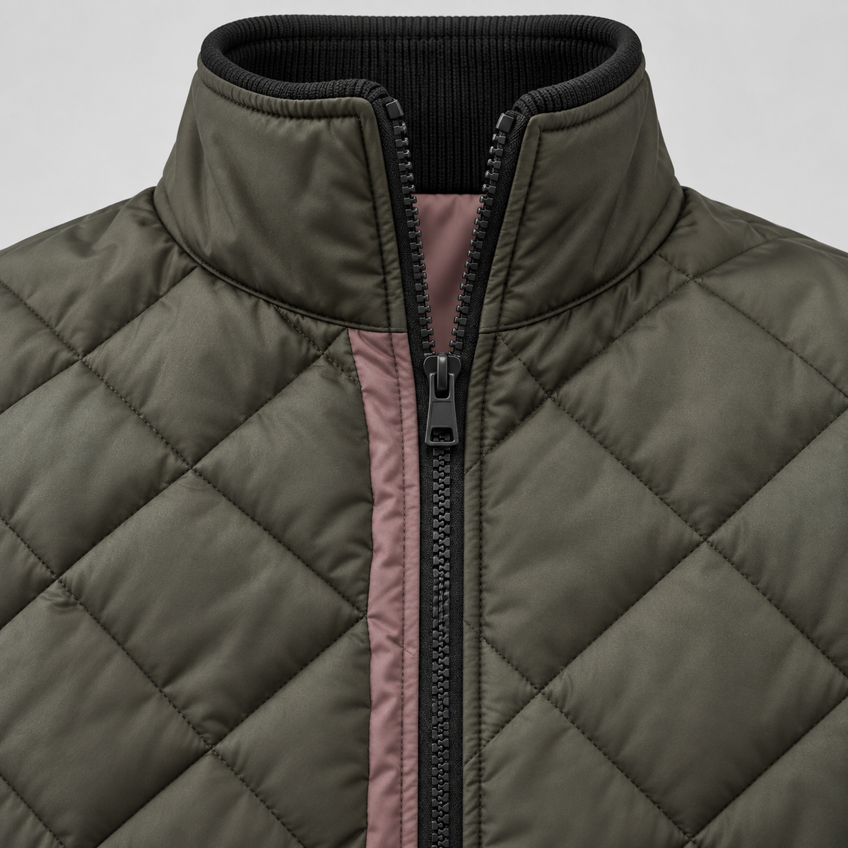 Close up of a dark olive quilted bomber jacket collar and zipper area with a pink inner placket and ribbed black collar trim.