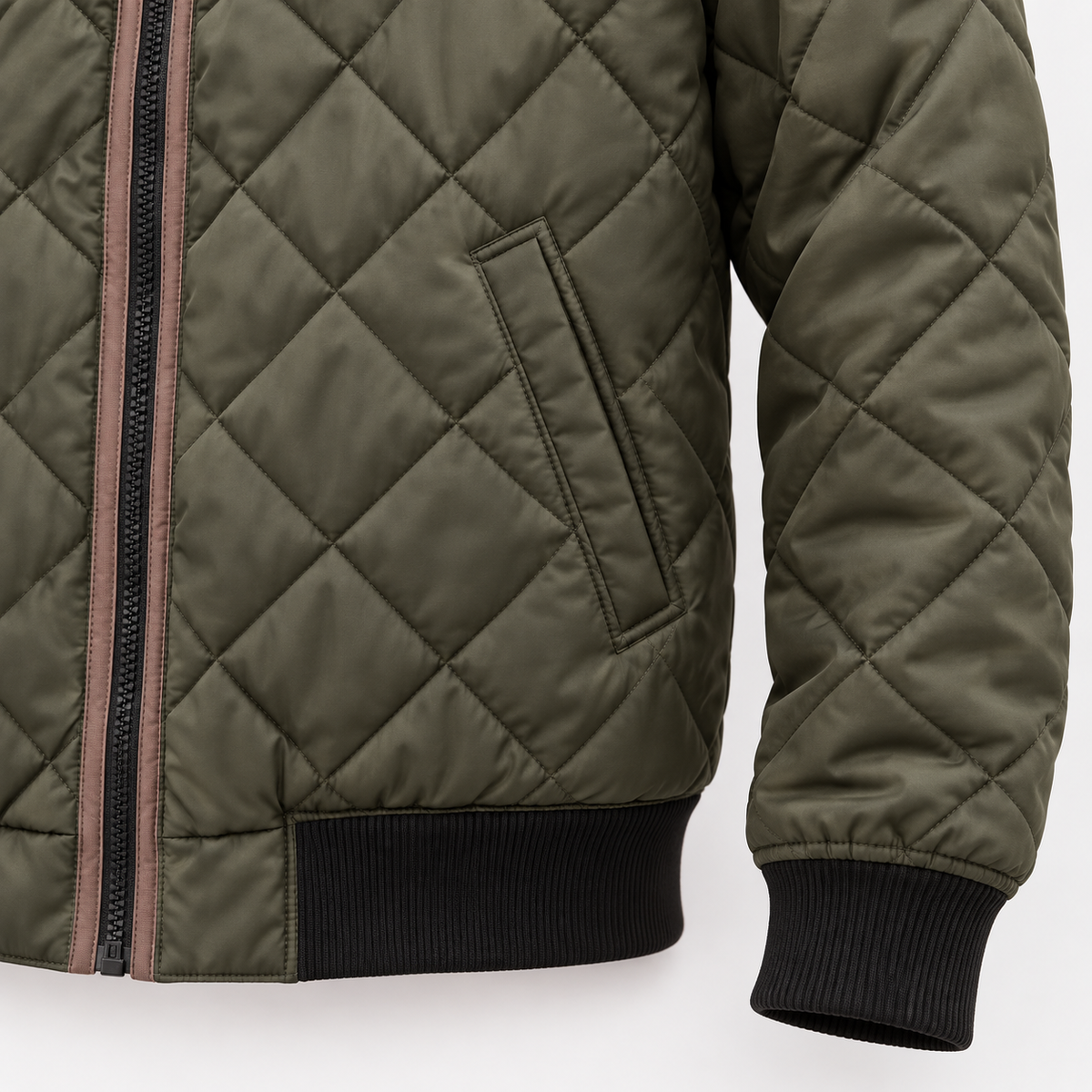 Close-up of an olive green diamond-quilted bomber jacket showing a zip, welt pocket and ribbed cuffs and hem.