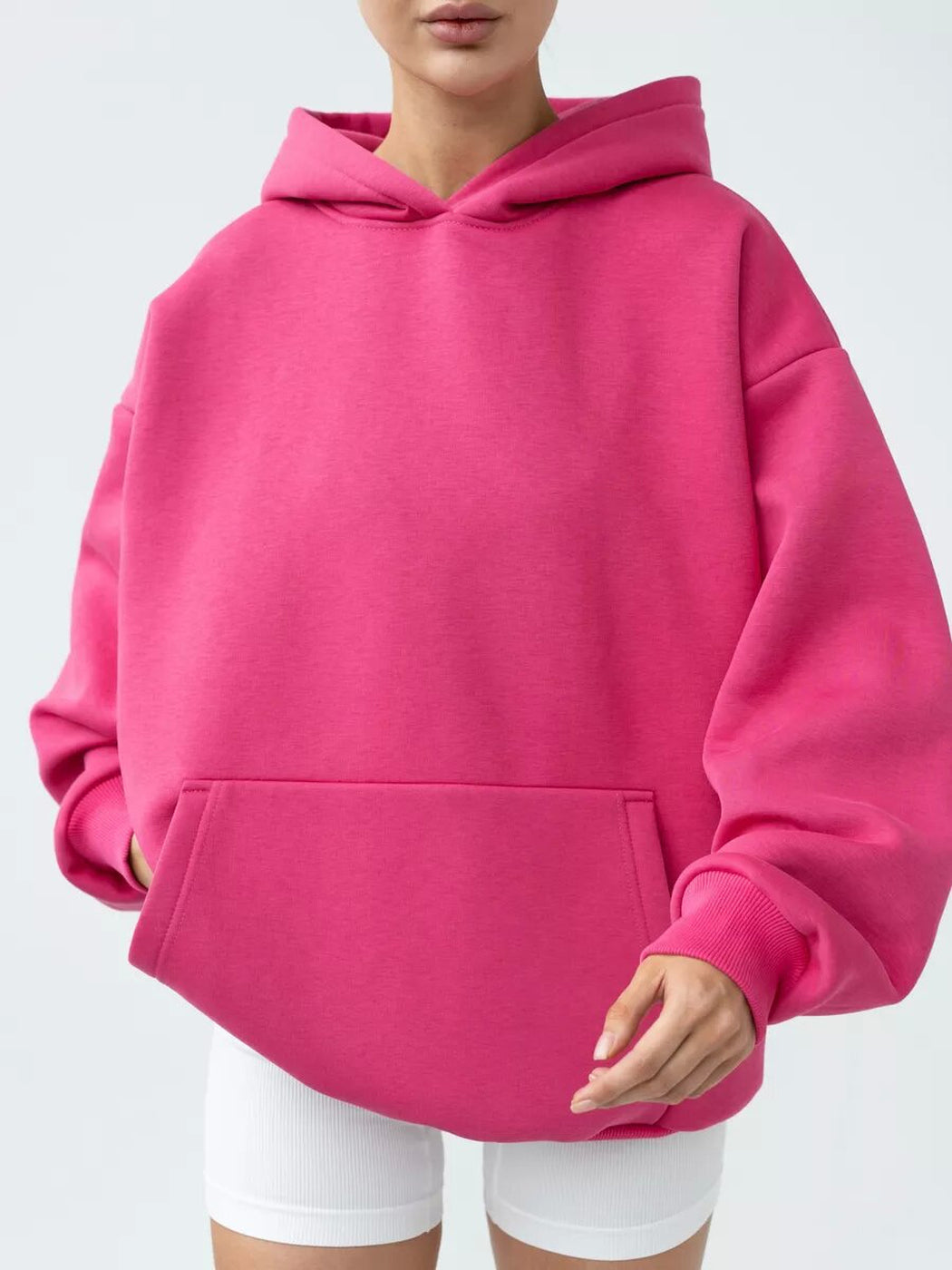 Vrouw in een magenta hoodie met verlaagde schouders en kangoeroezak | Boutique Moda