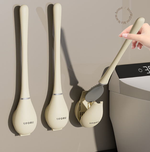 Beige siliconen wc-borstel met wandhouder, vastgehouden door een hand | Boutique Moda