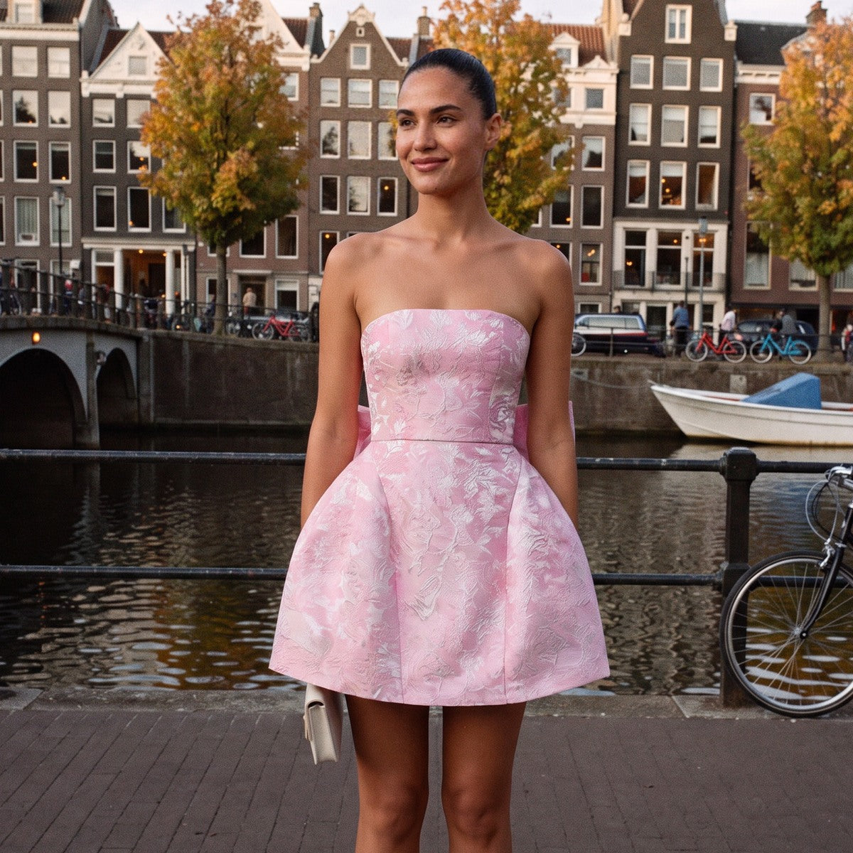 Strapless minijurk van jacquard met strik in roze, gedragen aan een Amsterdamse gracht