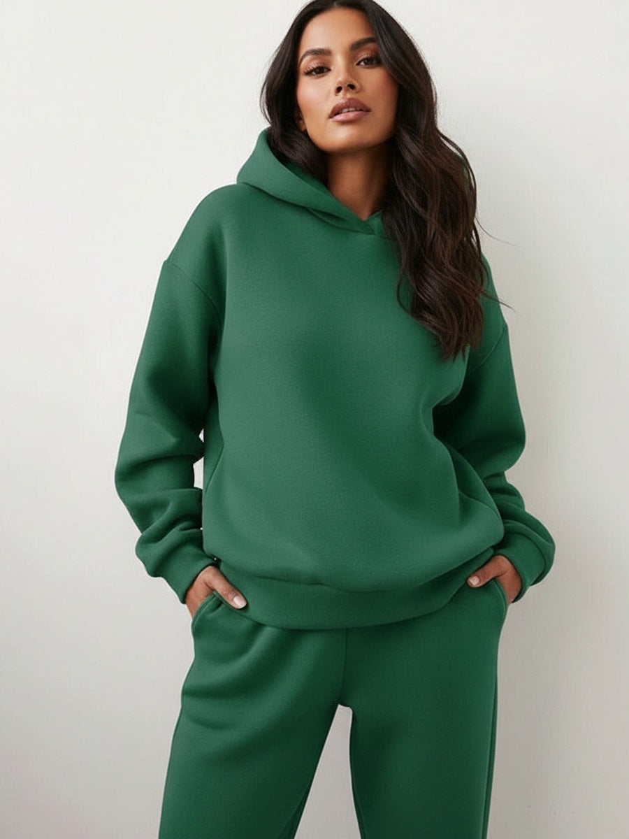 Oversized hoodie en joggingbroek in donkergroen, handen in de zakken