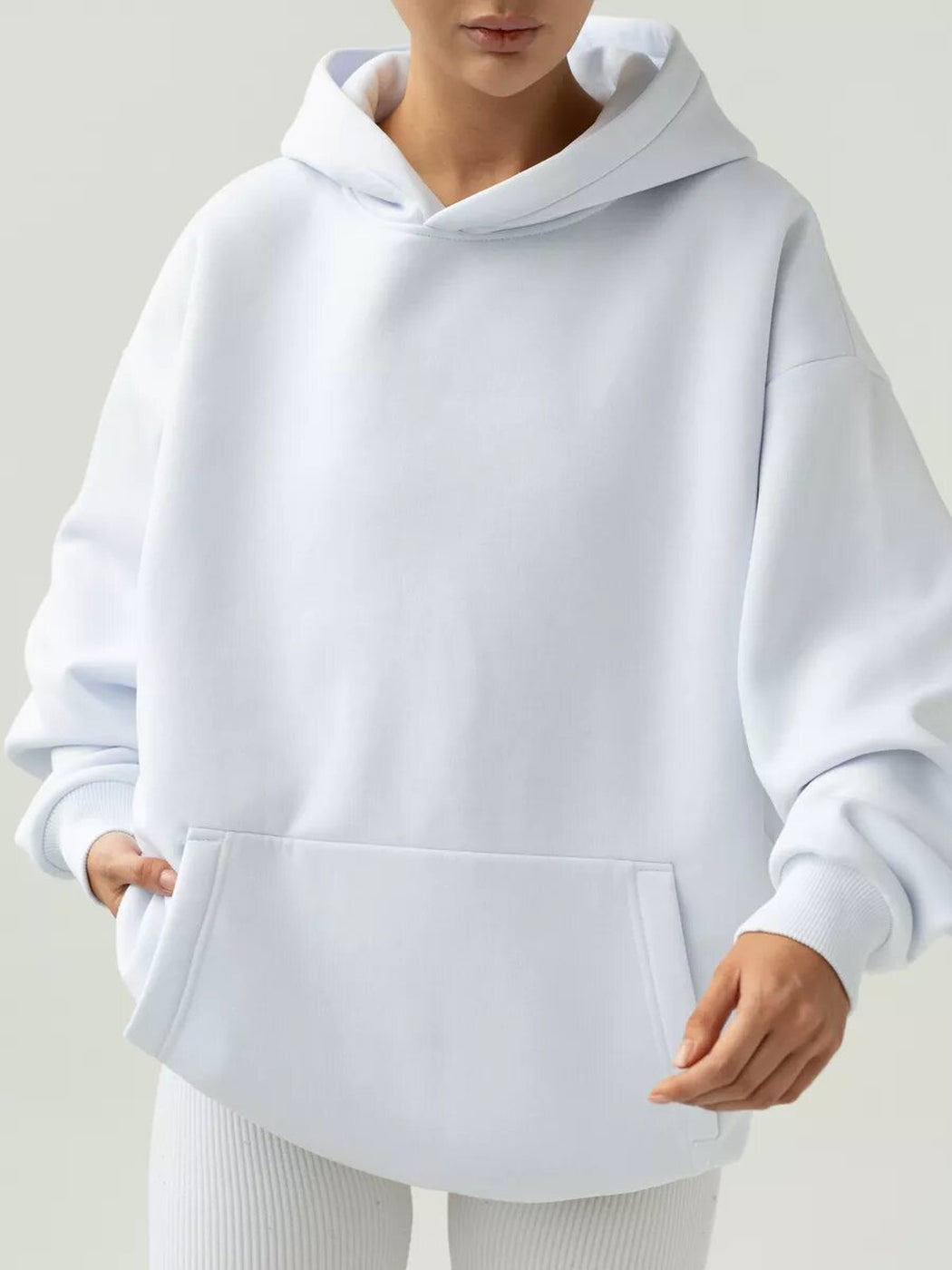 Vrouw in een witte hoodie met kangoeroezak en geribde boorden | Boutique Moda