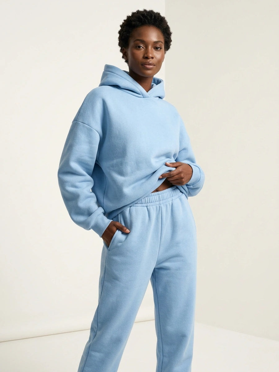 Oversized hoodie en joggingbroek in lichtblauw, handen in de zakken