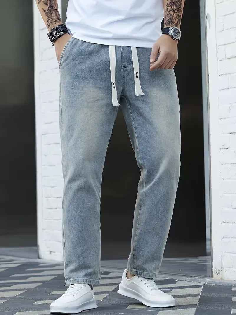 Joggerjeans voor heren in vintageblauw met trekkoord, gedragen, voorkant