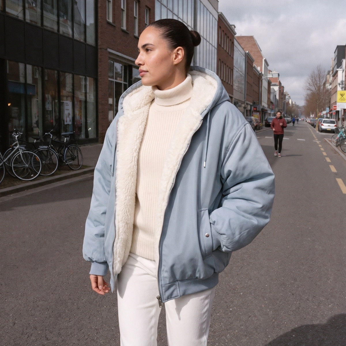 Oversized bomberjack voor dames in lichtblauw, open gedragen in een straat in Rotterdam
