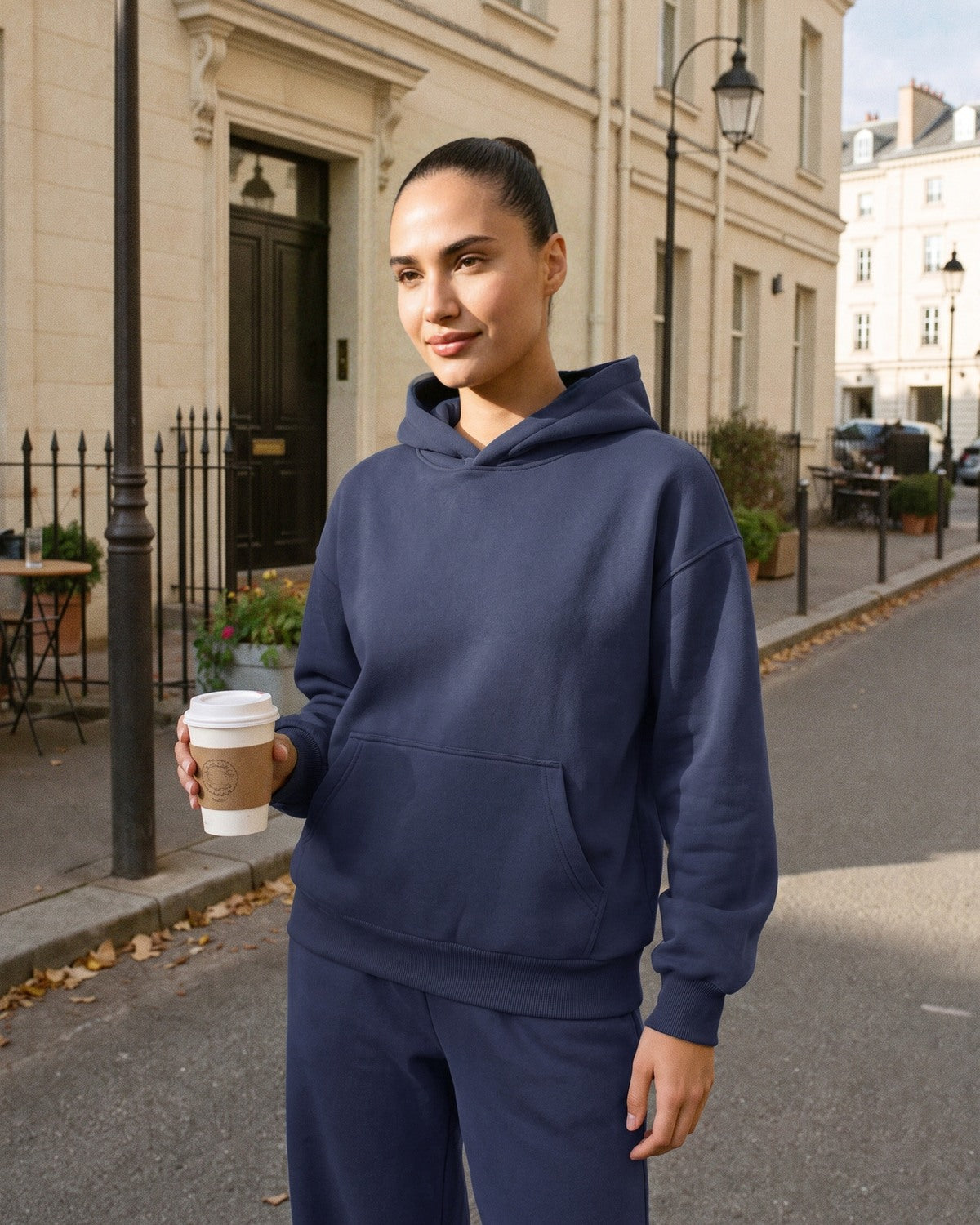 Marineblauw joggingpak, close-up van de fleece hoodie aan een model