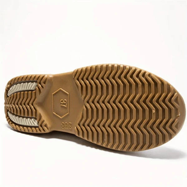 Underside of a single tan rubber boot sole with a zigzag tread, a moulded size 37 in a hexagon and small moulded symbols, on a white background.