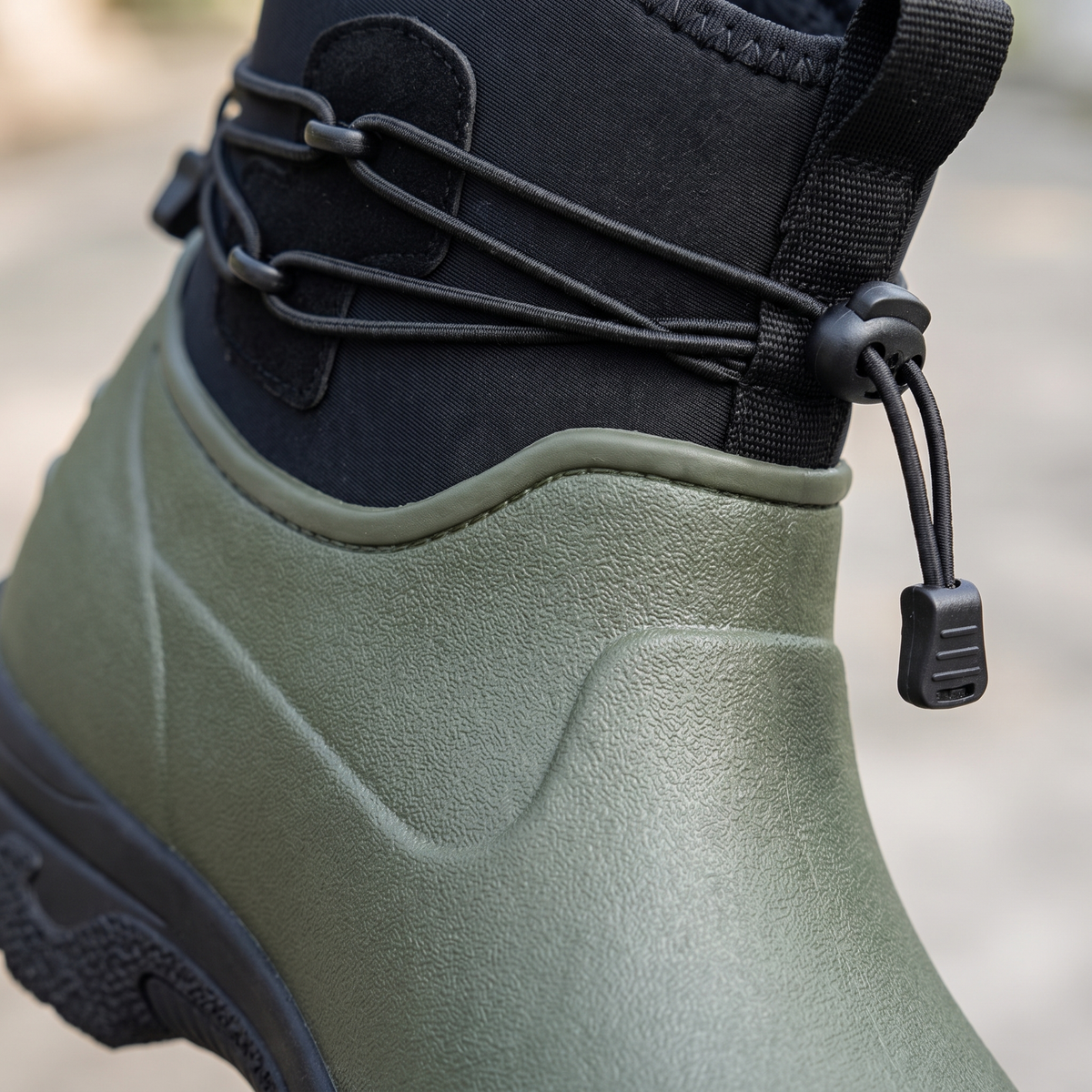 Groene regenlaars met zwarte bies en verstelbaar koord, close-up detail | Boutique Moda