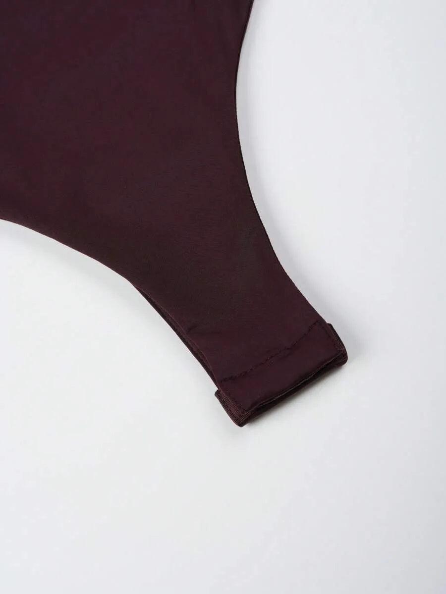 Close-up of a dark burgundy garment's sleeve cuff with a folded hem on a white background.