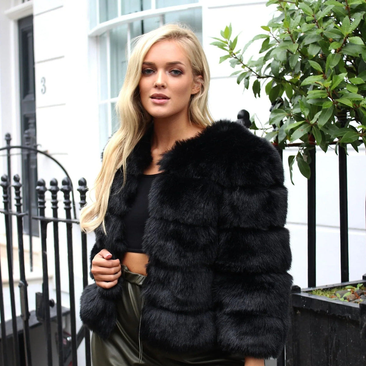 Zwart kort fluffy imitatiebont jasje gedragen door vrouw op straat | Boutique Moda