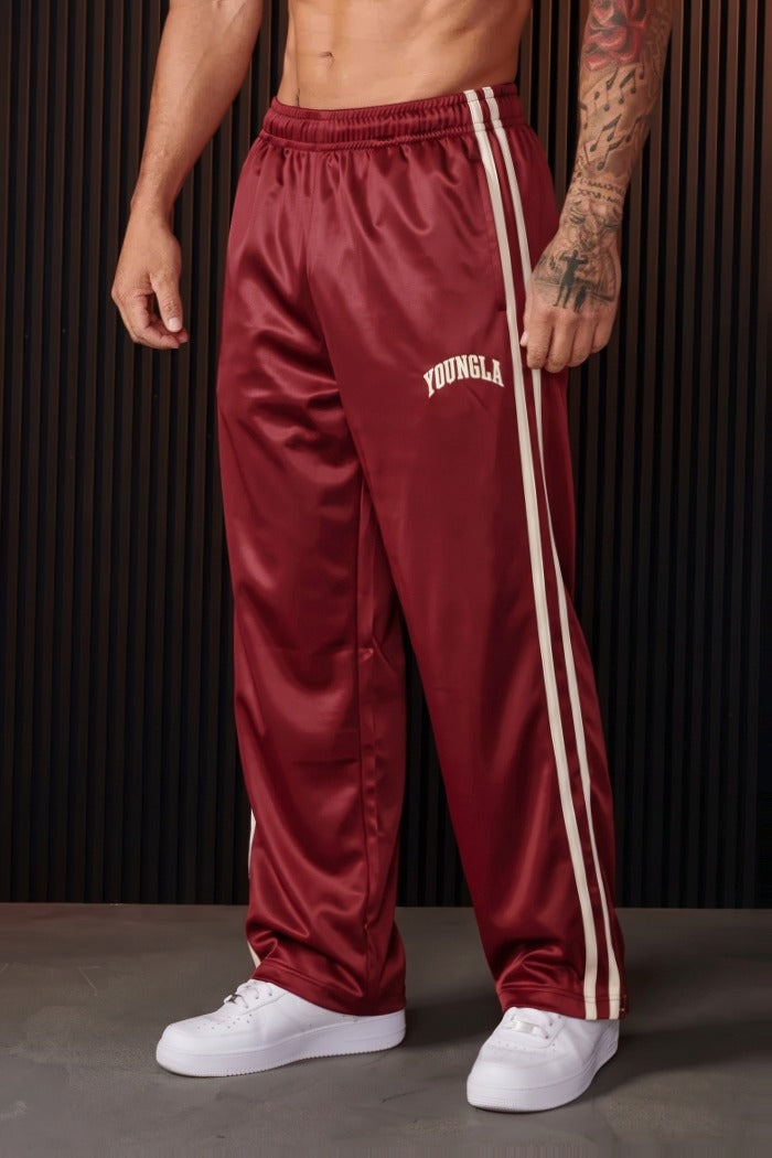 Bordeauxrode joggingbroek met witte zijstrepen, gedragen door een man | Boutique Moda