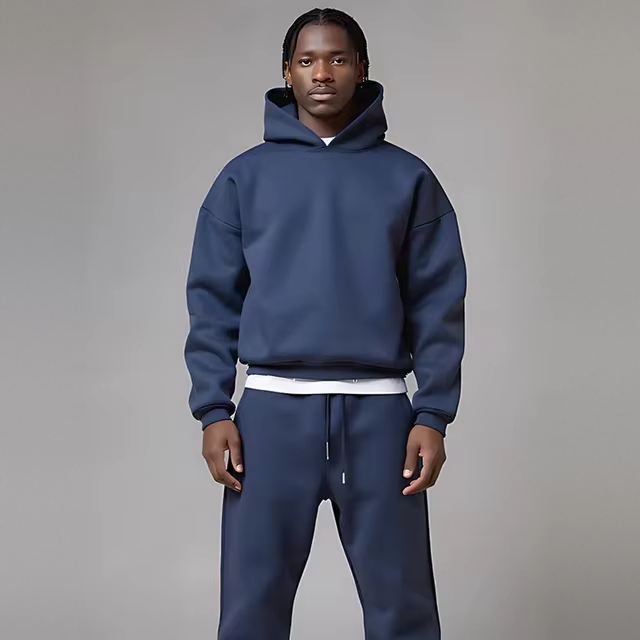 Man draagt marineblauwe hoodie met joggingbroek, effen kleur, casual outfit | Boutique Moda