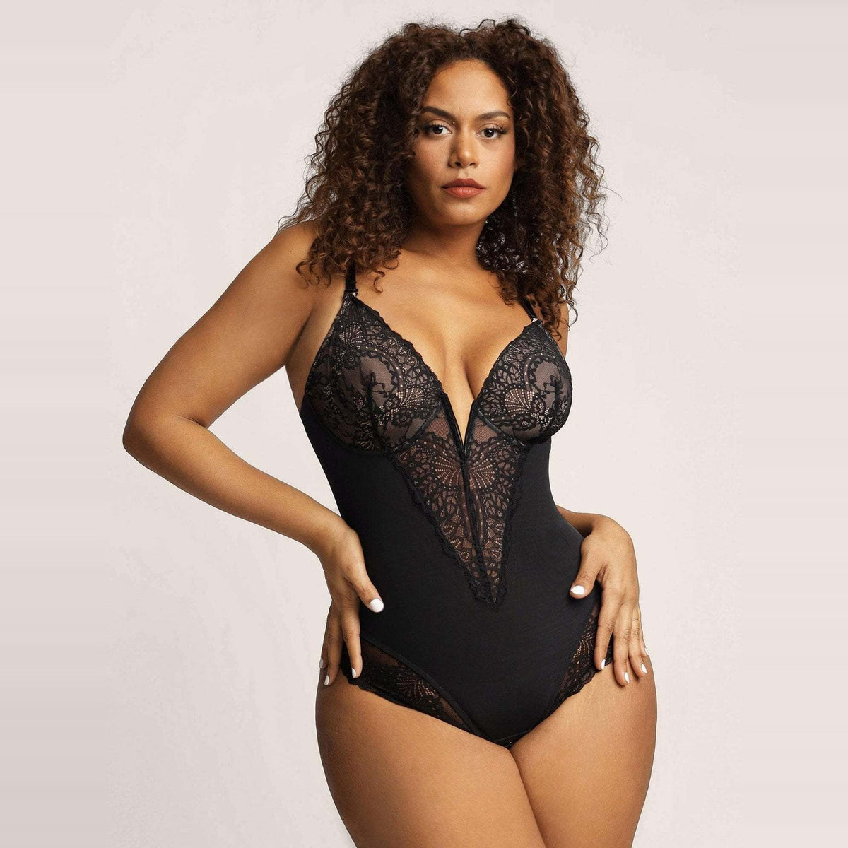 Zwarte kanten bodysuit met diepe V-hals, gedragen door model | Boutique Moda