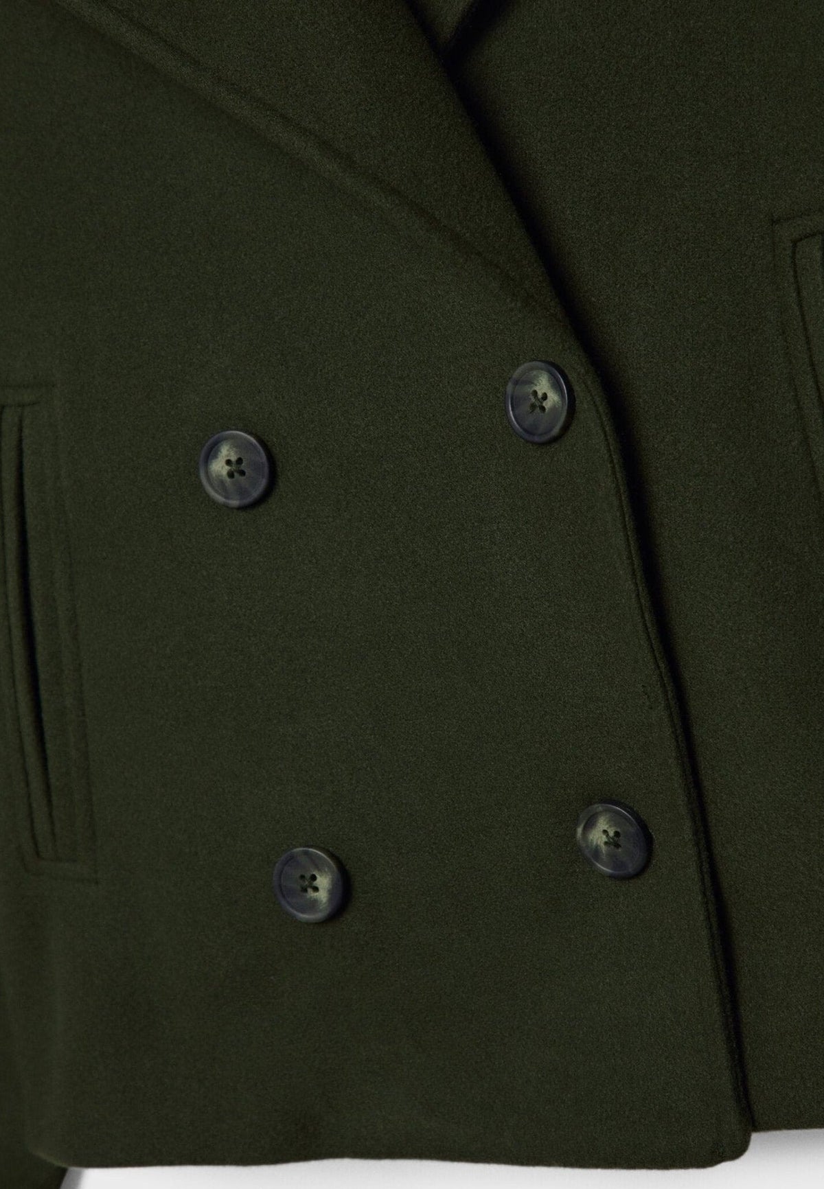 Detail van groene wollen jas met dubbele rij knopen en paspelzak | Boutique Moda