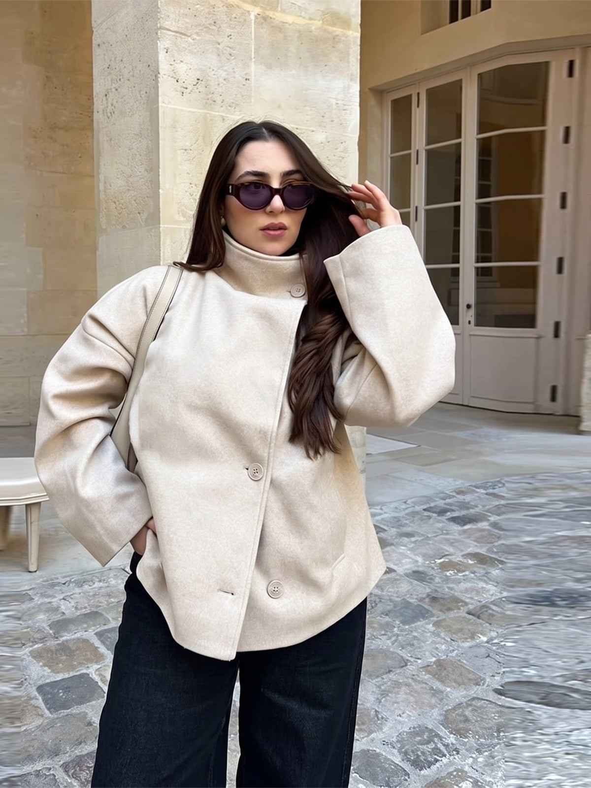 Beige oversized korte jas met opstaande kraag, gedragen door vrouw buiten | Boutique Moda