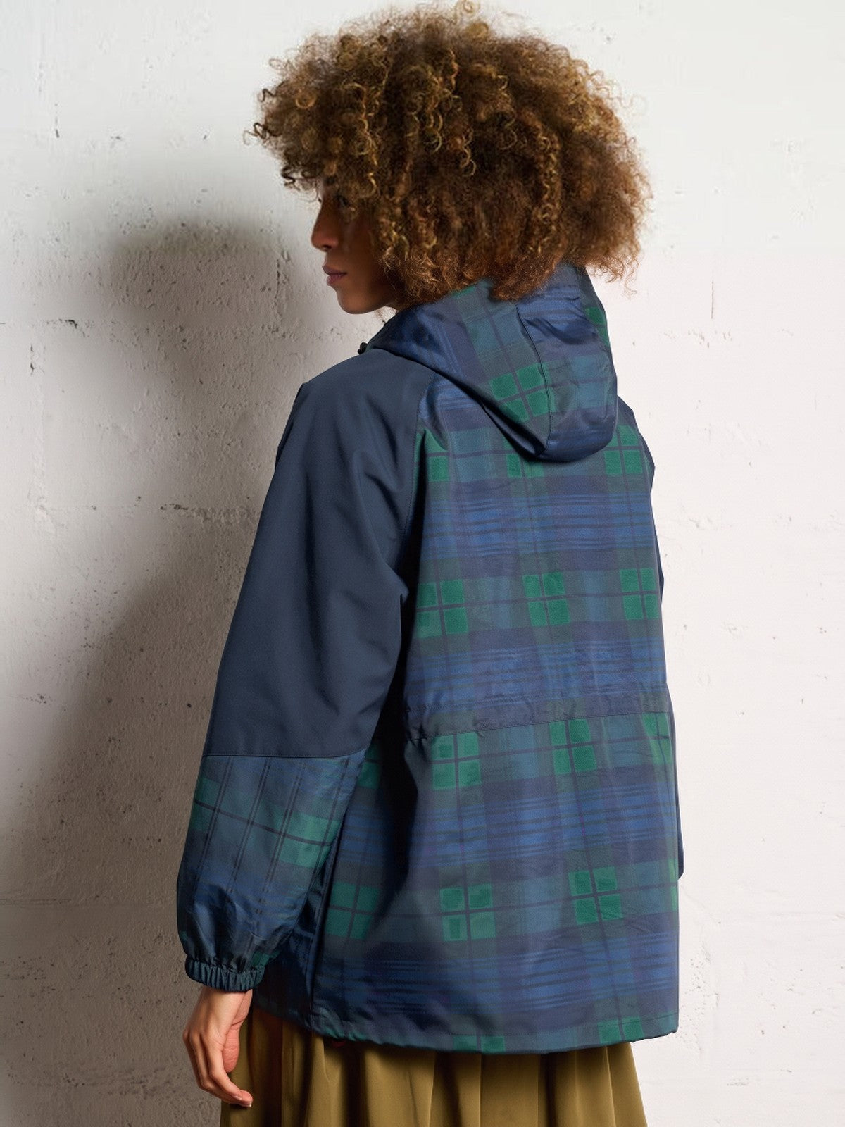Achterkant van de geruite blauwgroene regenjas met geruite capuchon en navy mouwen | Boutique Moda