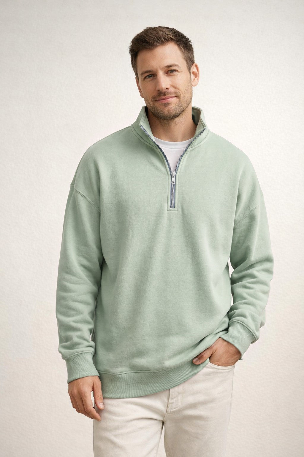 Man draagt groene sweater met halve rits en witte broek | Boutique Moda