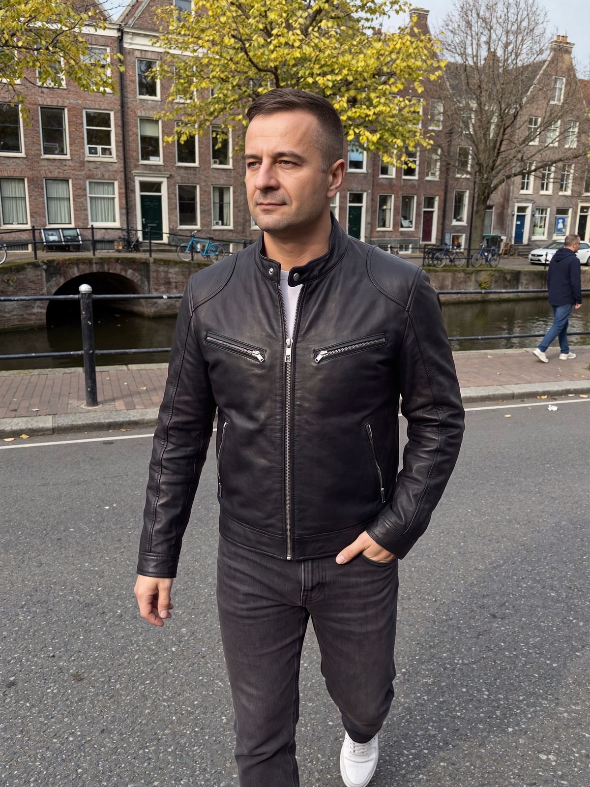 Man draagt zwarte bikerjas van veganistisch leer aan een gracht in Utrecht | Boutique Moda