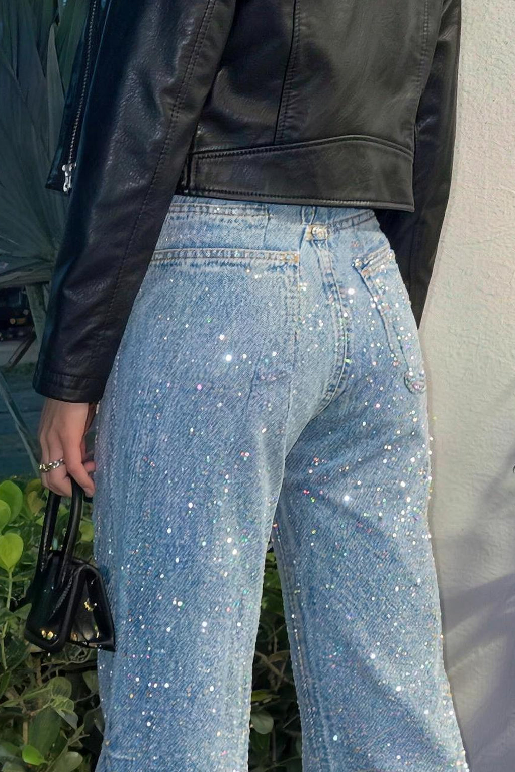 Lichtblauwe glitter spijkerbroek met hoge taille, gedragen door vrouw met zwart jasje | Boutique Moda